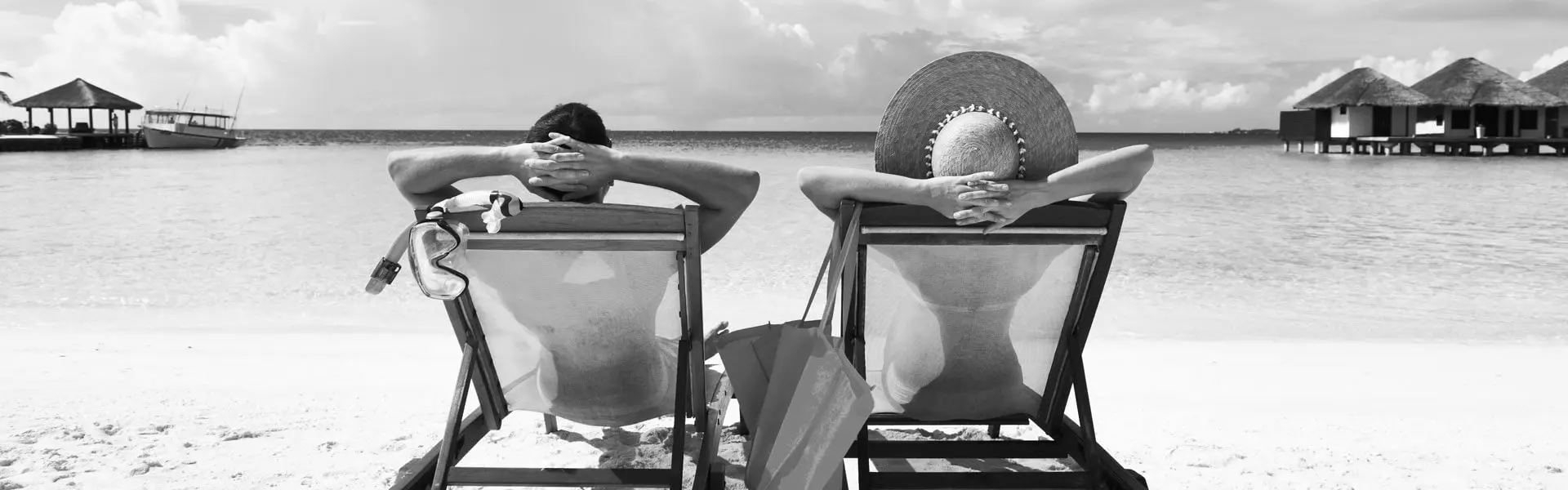 Header-couple-laying-on-chairs-on-beach